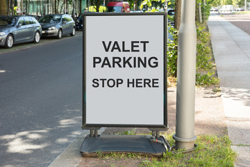 Valet parking sign on board by street