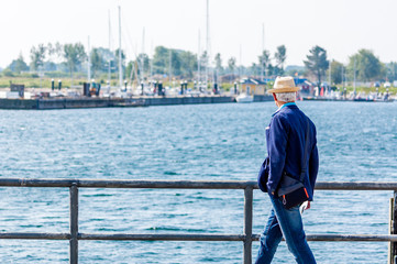 Mann mit Hut geht spazieren an der Ostsee