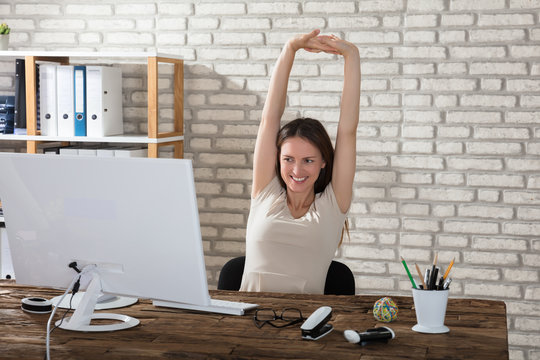 Businesswoman Stretching Her Arms In Office