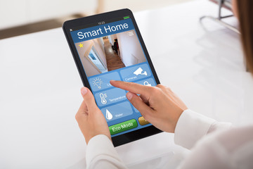 Person Using Smart Home System On Digital Tablet
