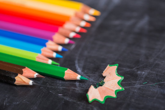 Color pencils over blackboard background