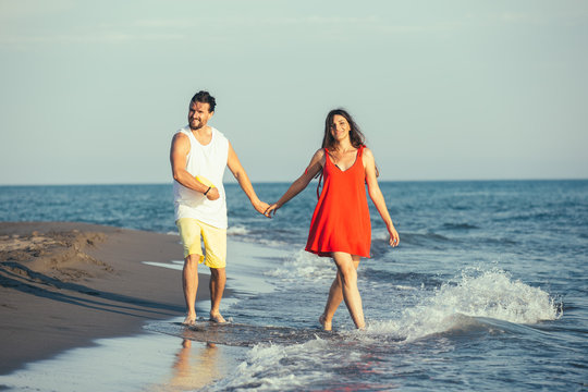 Young couple holding hands on the beach