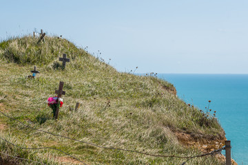 Flowers and crosses on cliff top over blue sea at Beachy Head suicide spot