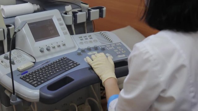 Woman doctor working behind the ultrasound device
