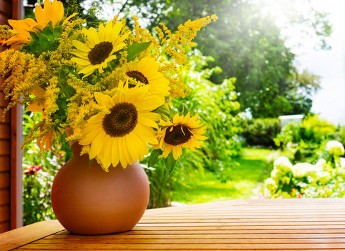 Sonnenblumen und Goldrute auf dem Gartentisch