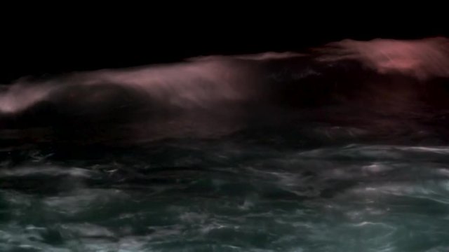 Big surf waves at the ocean at night.