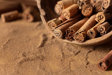 Cinnamon rolls and powder on a wooden ground