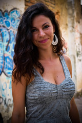 Fototapeta premium Beautiful girl posing beside a rustic wall