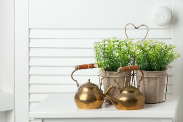 Brass teapots on white door background