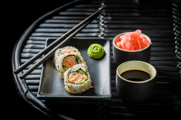 Fresh sushi made of salmon and avocado on black table