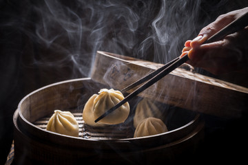 Boiled and hot chinese dumplings on black background - obrazy, fototapety, plakaty