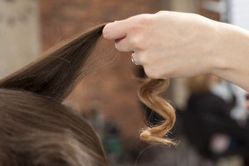 curly strand of hair in the hand of hairdresser © vladimirfloyd