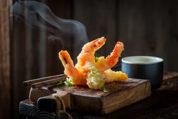 Tragetasche Tasty shrimp in tempura with red sauce on black background © shaiith