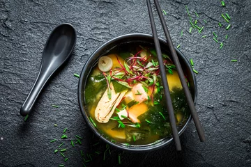 Photo sur Plexiglas Plats de repas Soupe miso chaude et savoureuse au saumon sur rocher noir