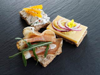 Snacks dekoriert mit frischen Kräutern auf Schiefertafel