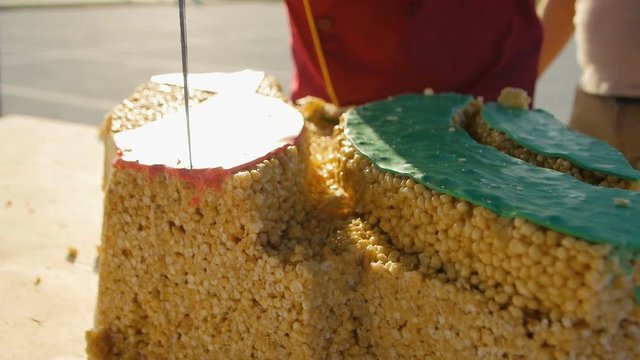 Man Cuts Traditional Dish Covered with Red and Green Glaze