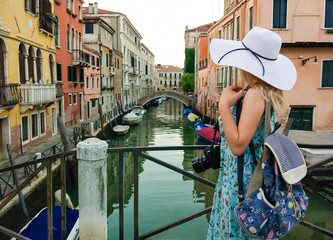 Fototapeta na wymiar beautiful lady with a big straw hat taking a picture in Venice in Italy