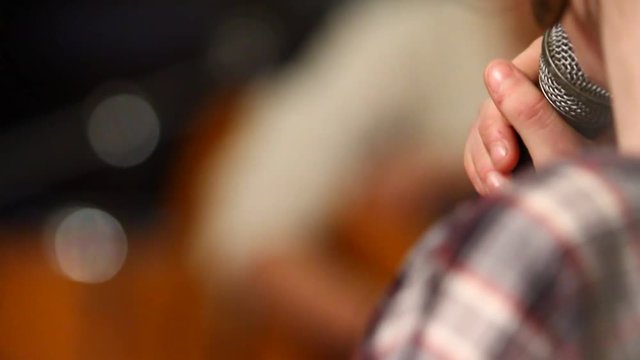 Ragazza canta al microfono di schiena
