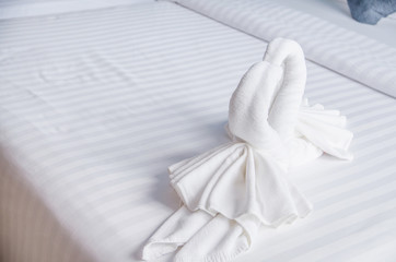 swan of white towel on bed