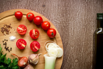 Fresh organic ingredients for salad making: spinach, tomatoes, sprouts, basil, olive oil on rustic background, top view.