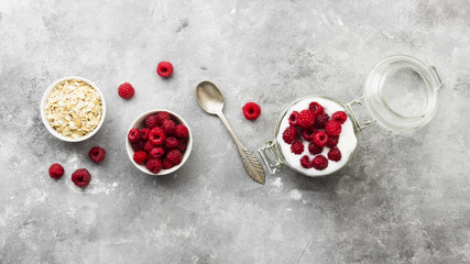 Glanola in glass jar with raspberry on a gray background. Top view. Food background