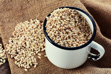 Pearl barley grain seed on wooden background