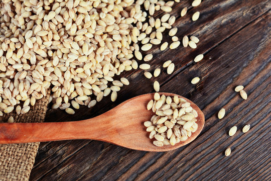Pearl barley grain seed on wooden background
