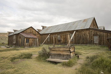 Obraz premium Wooden well outside barn in field, Bodie