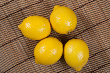 Still life of fresh lemons on a bamboo napkin