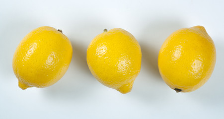 Still life of three fresh lemons on a white