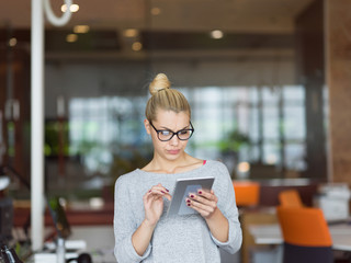 woman working on digital tablet in night office