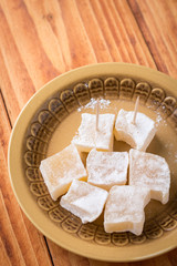 Flat lay above served turkish delight on the plate on the wooden table