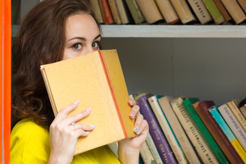 Cute girl with old book in public book booth in Prague