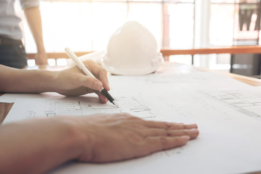 Image of engineer or architectural project, Close up of Architects engineer's hands drawing plan on BluePrint with Engineering tools on workplace, Construction concept
