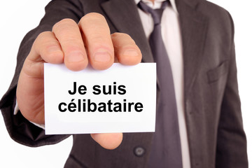 Homme tenant une carte avec je suis célibataire écrit dessus 