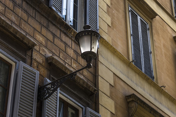 Beautiful street lantern of wrought iron and a glass lampshade on the facade of an old building, Rome, Italy