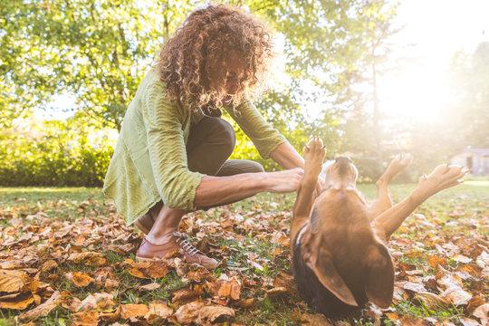 Woman Playing With A Dog In The Garden