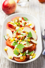 Tomato, corn, peach and feta salad. Selective focus, close up.