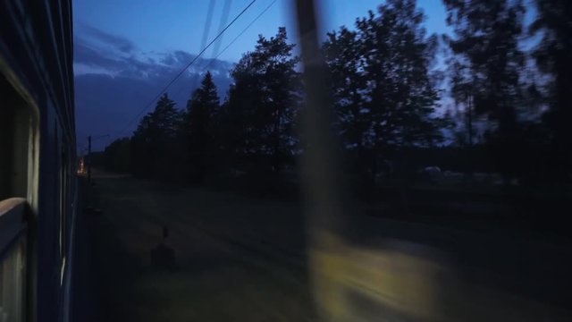 Night, the train is traveling by rail, view from the train window, the blue sky.
