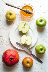 Fruits and honey on a white table for the Rosh Hashanah