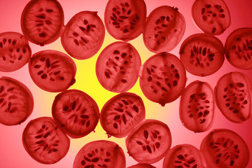 Cut gooseberry berries in transmitted light. Multicolored background.