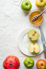 Halves of apples in honey on a ceramic plate, pomegranate on a white table