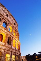 Naklejka na ściany i meble Colosseum at night with bright lighted arches.