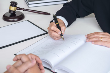 Close up of gavel, Male lawyer or judge Consult with client and working with Law books, report the case on table in modern office, Law and justice concept