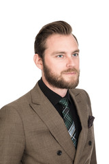 Handsome tough bearded businesman in a brown suit, black shirt and tie. Standing against a white background smiling.