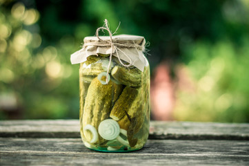 Bank with pickled cucumbers on a wooden surface