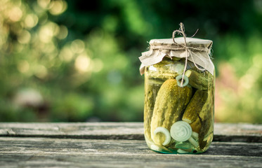 Bank with pickled cucumbers on a wooden surface