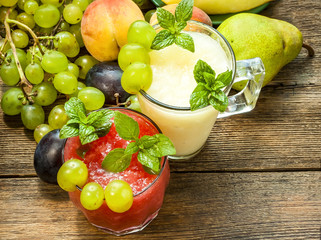 Watermelon and melon smoothies, grapes and plums. Wooden background