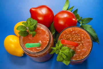 Tomato smoothies. Red and yellow tomatoes. blue background