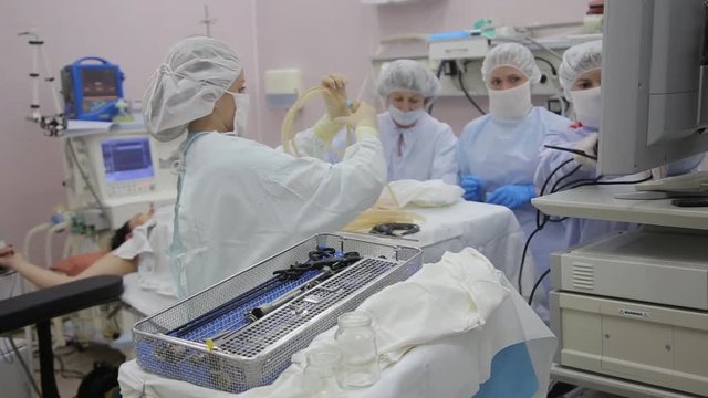 A team of surgeon assistants prepare the surgical room for sterilization after the operation is completed. After a surgical operation